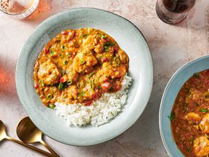 Shrimp Ã©touffÃ©e in a soup plate with rice and thinly sliced scallions