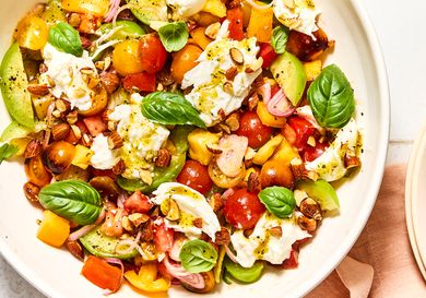 Tomato salad with sliced vegetables and fresh herbs in a bowl