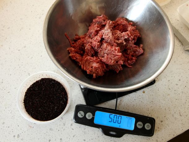 Ground lamb being weighed with a digital scale, which reads 500 grams.