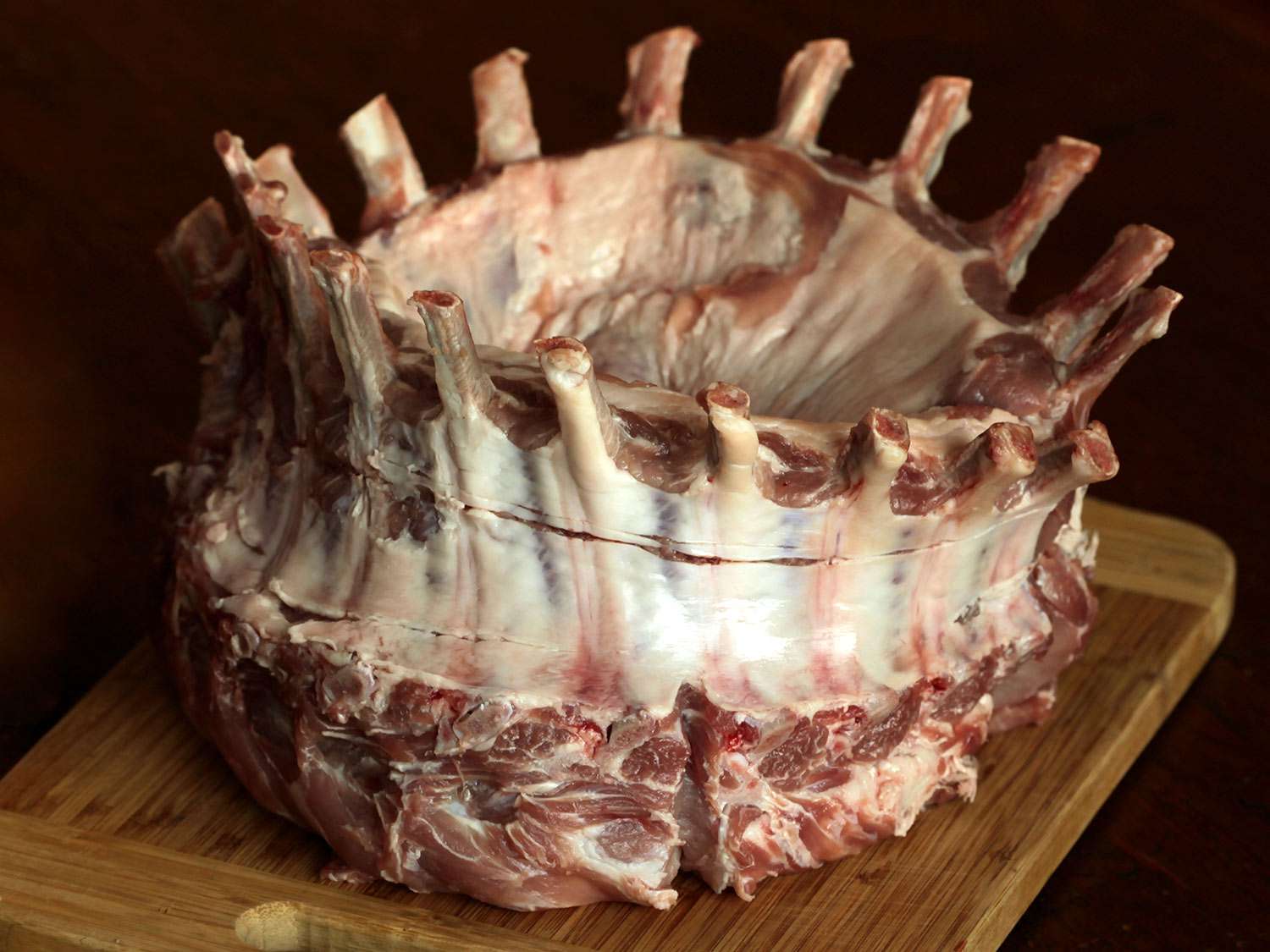 A raw crown roast on a cutting board. 