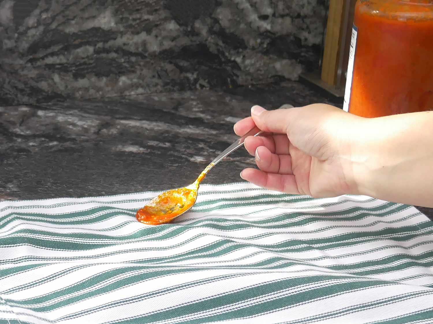 a person staining an apron with tomato sauce