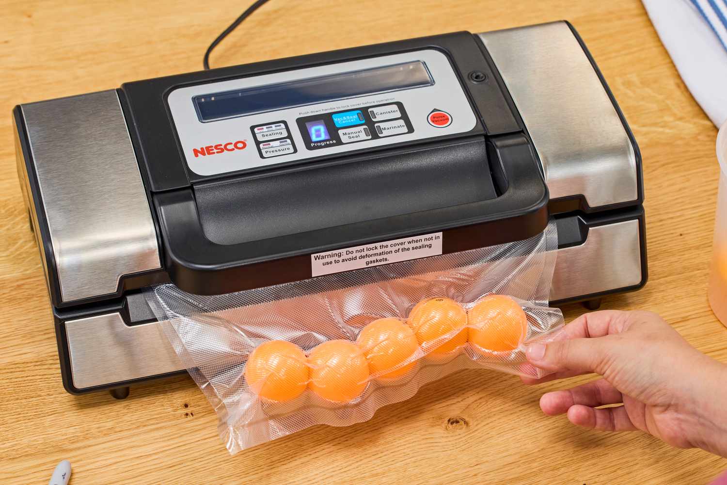 A bag of ping pong balls is vacuum sealed using the Nesco VS-12 Deluxe Vacuum Sealer