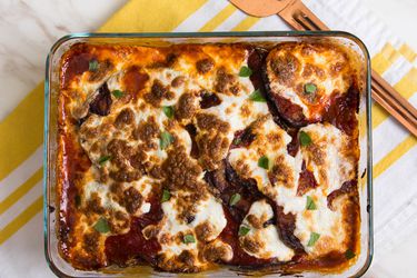 Baking dish of Italian-style eggplant parm with a golden topping of melted cheese