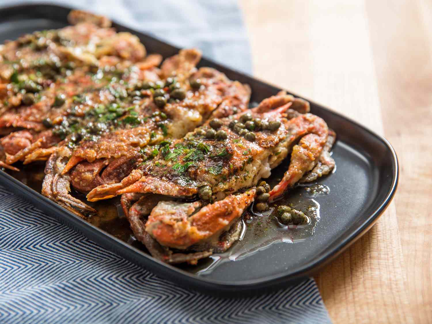 Sautéed Soft-Shell Crabs With Lemon-Butter Pan Sauce, served on a black oblong platter.