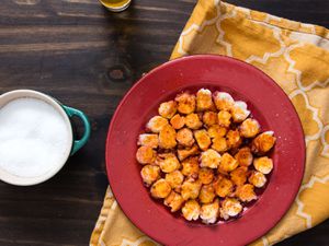 Overhead view of pulpo gallego served on a red plate.