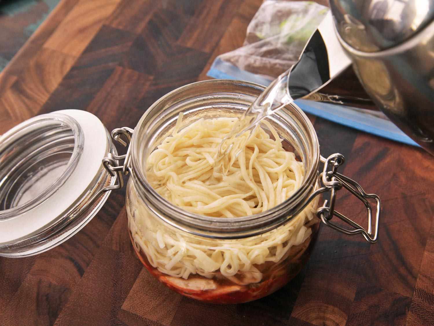 Boiling water is added to the jar of homemade instant noodles.