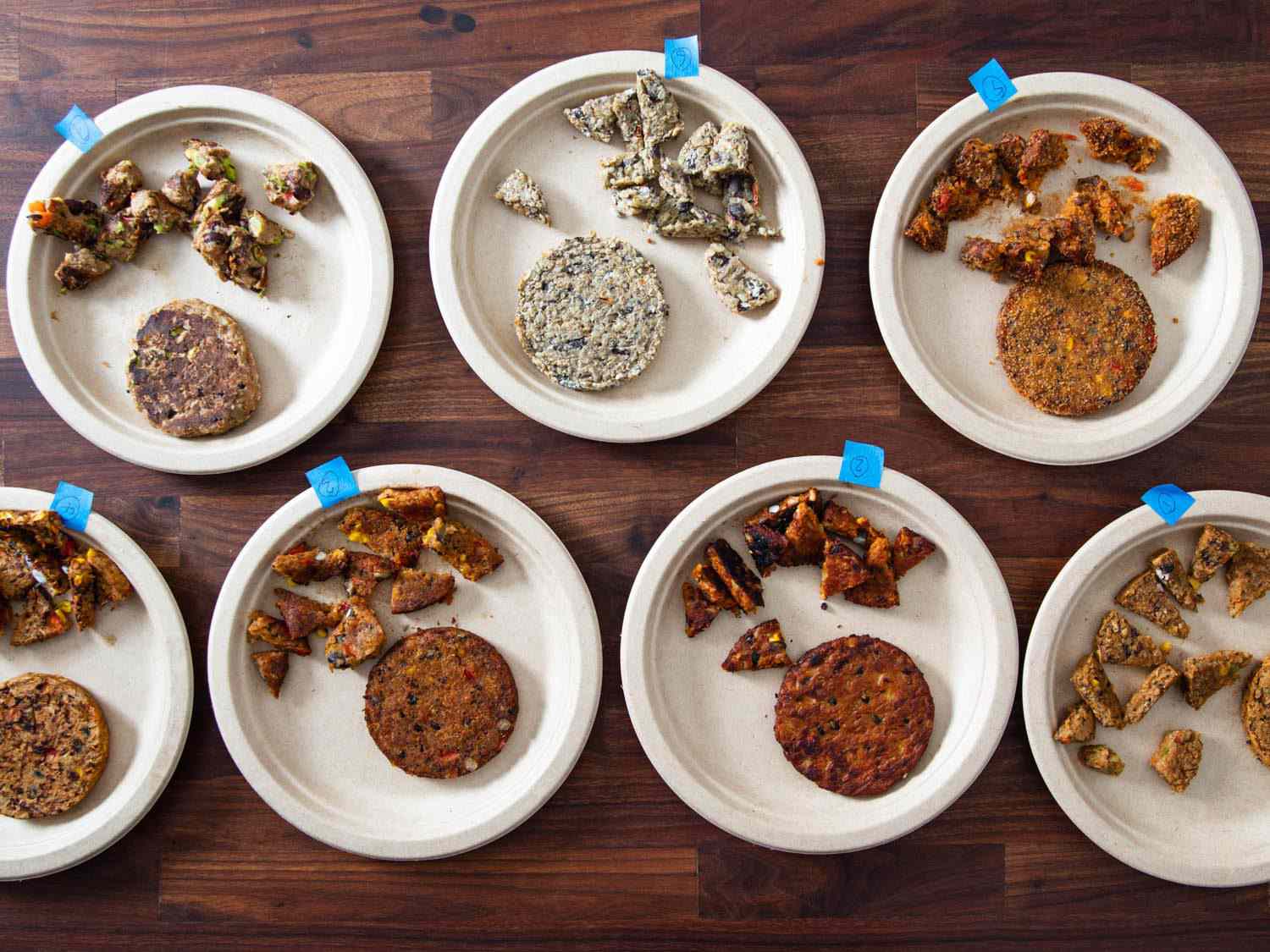 Overhead view of numbered paper plates with black bean burgers cut up for tasting on each one