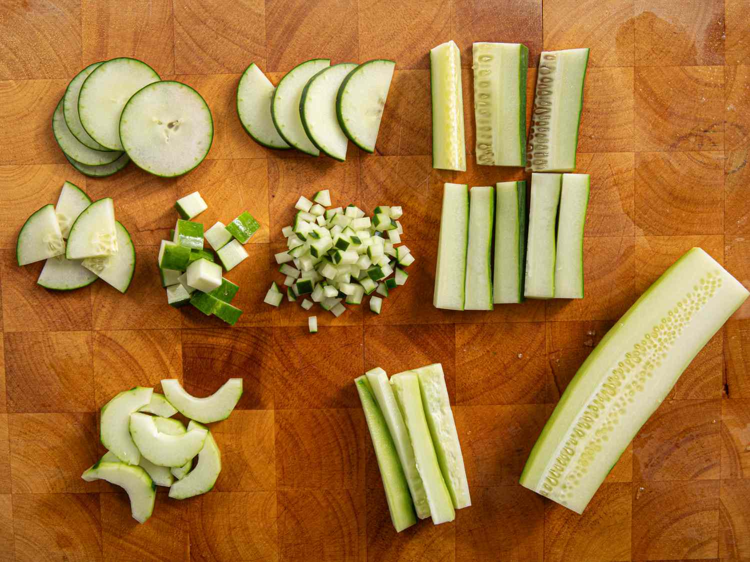 Overhead view of cucumbers cut in a bunch of different ways.