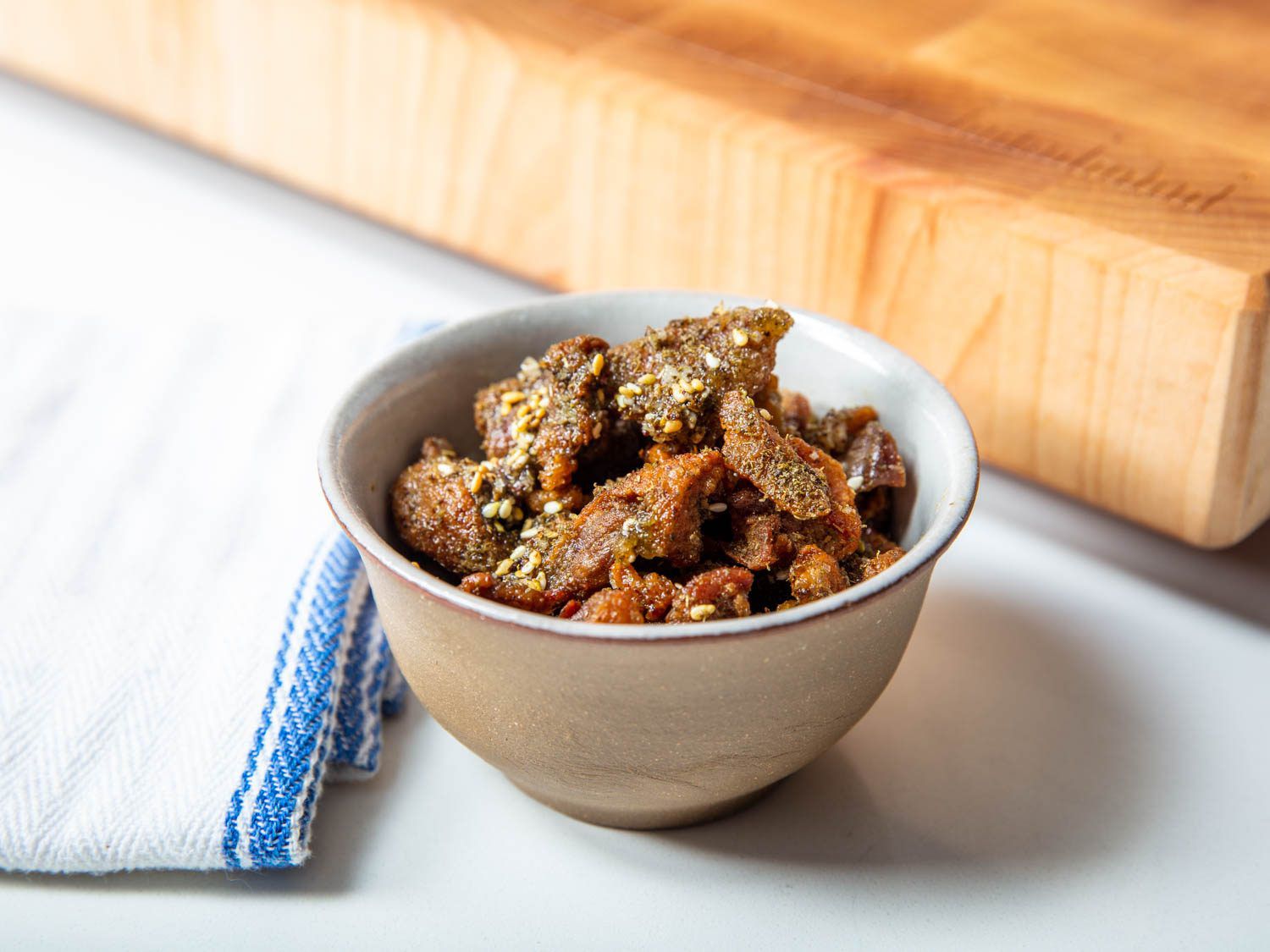 Closeup of a bowl of duck cracklings with za'atar and sea salt.
