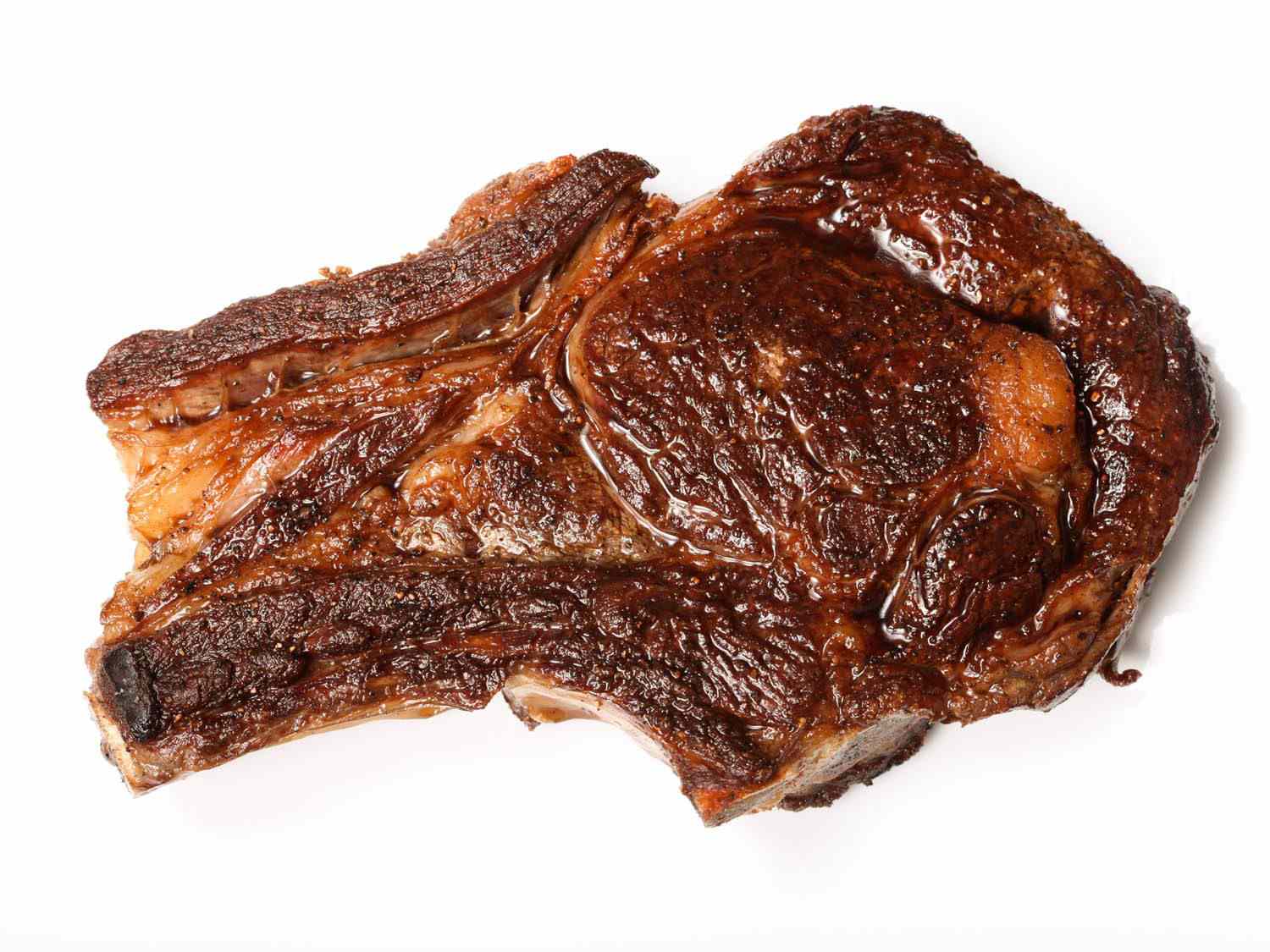 Dark golden brown cooked steak on white background.