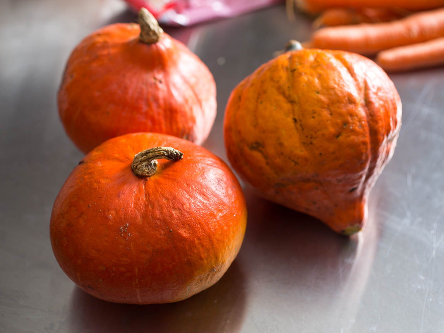 Several small orange squashes placed on a prep table.