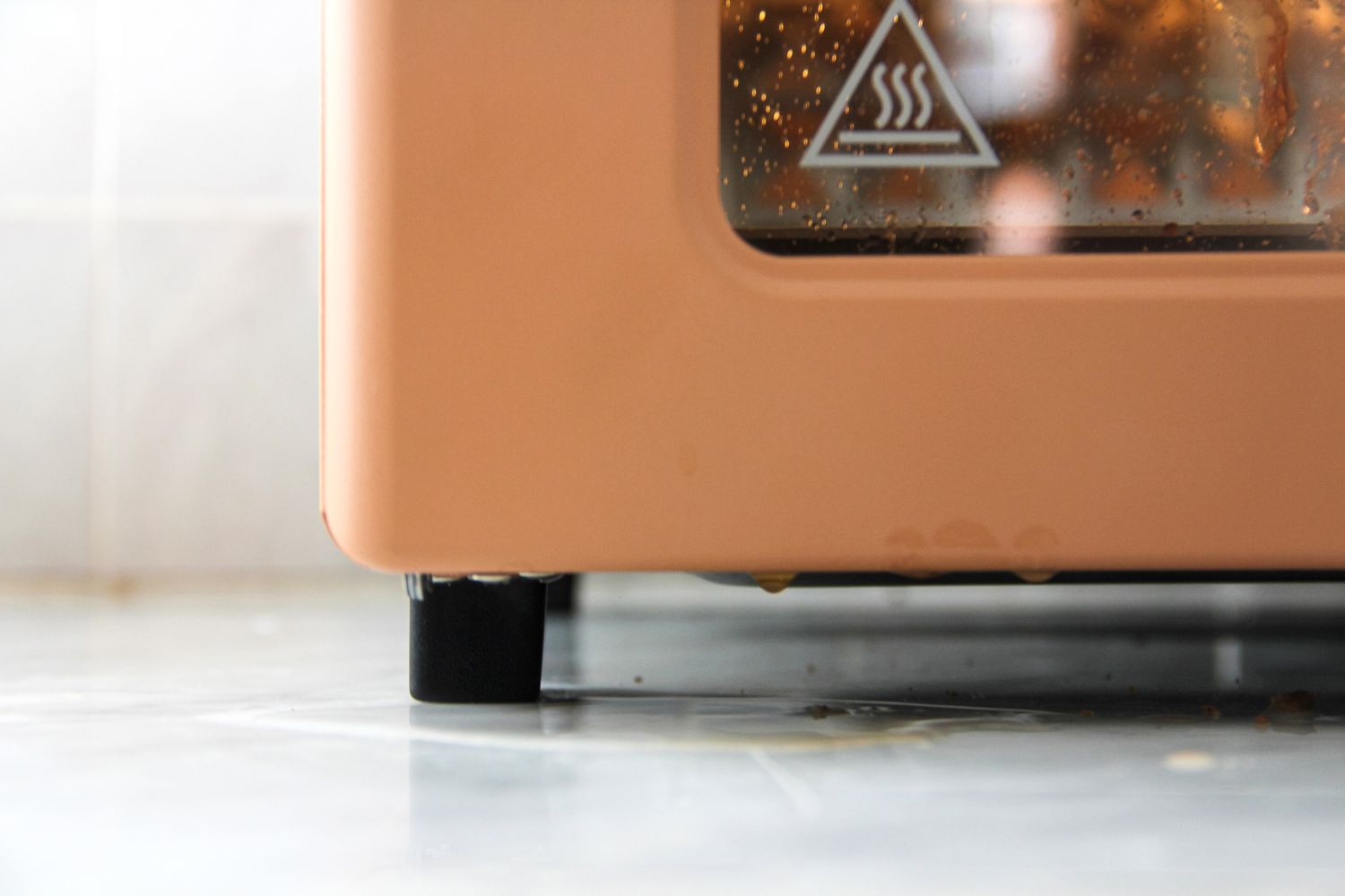 Close-up of the lower part of a kitchen appliance, showing a steam icon and resting on a kitchen counter