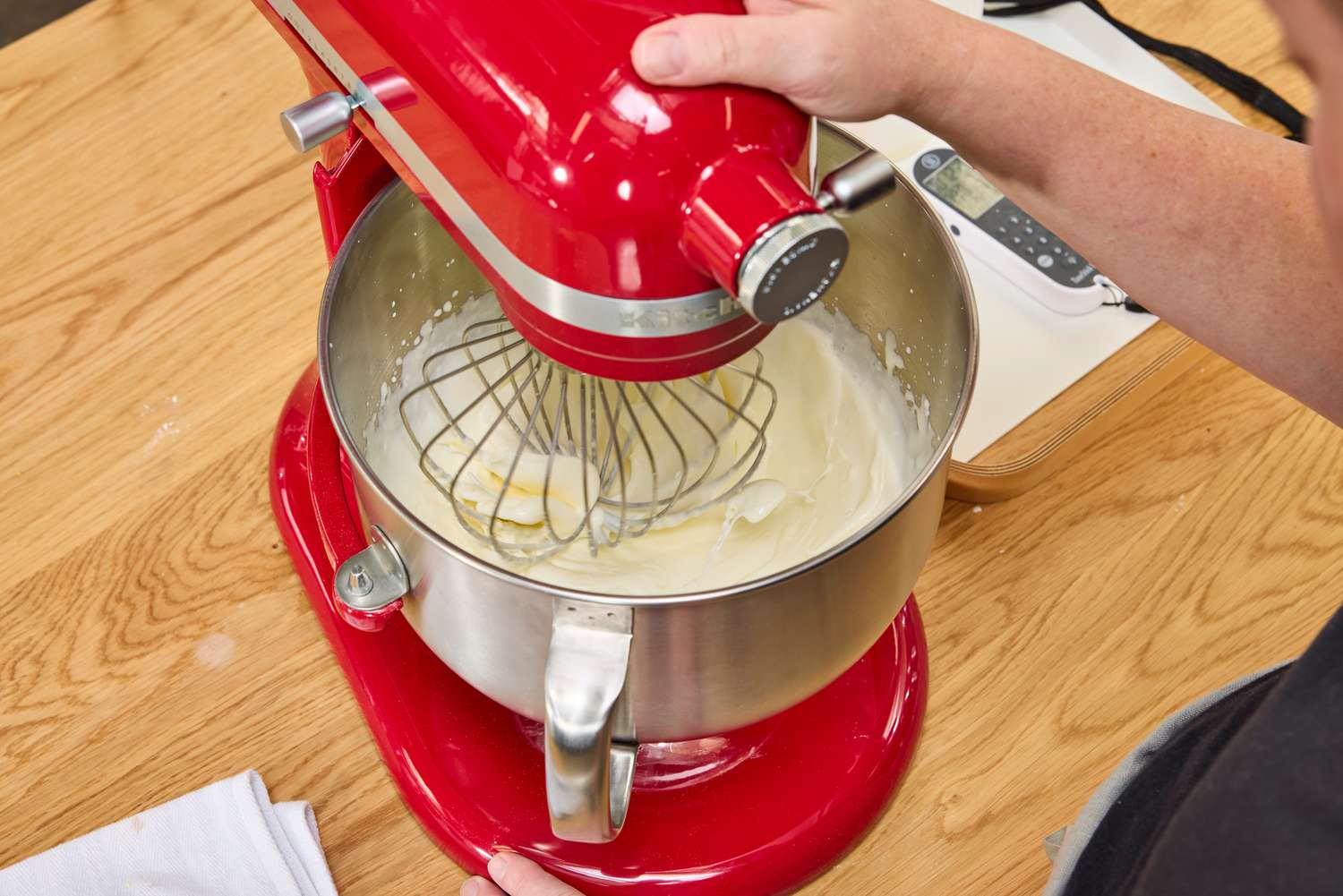 A person whips cream in the KitchenAid 7 Quart Bowl Lift Stand Mixer