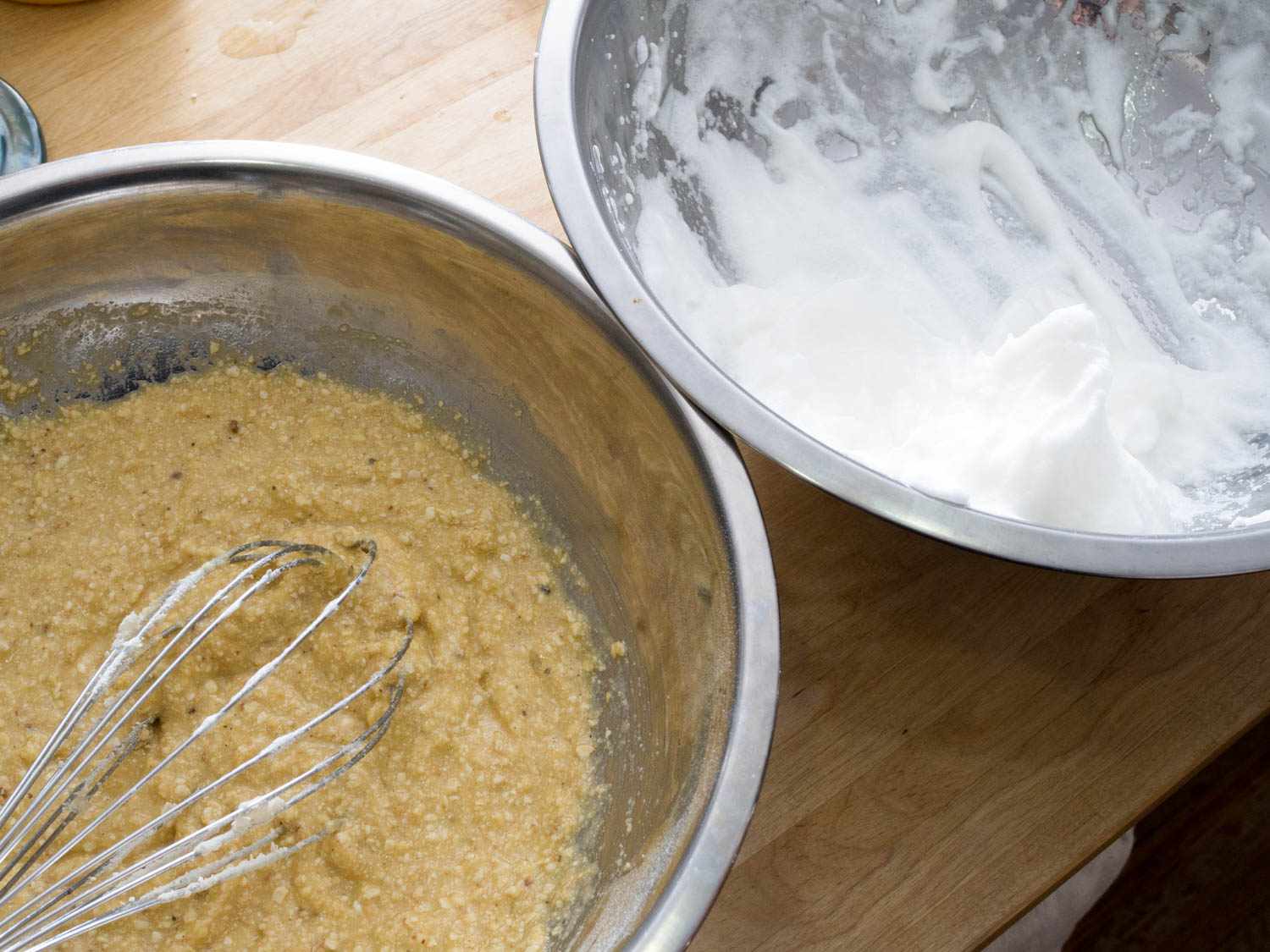 Bowls of just-mixed matzo-ball mixture and beaten egg whites about to be folded together.
