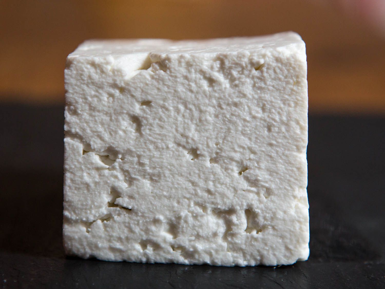 A closeup of a square block of Greek feta cheese.
