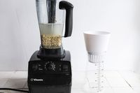a blender with soaking nuts and the chefn next to it