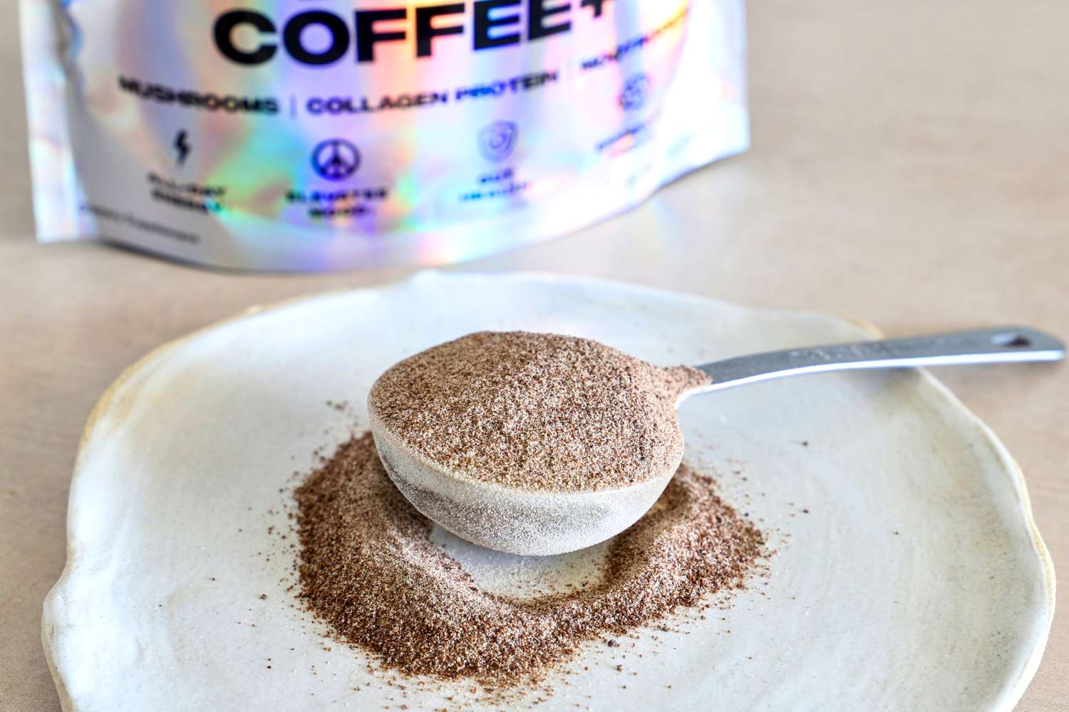 A scoop filled with powdered mixture rests on a plate, with a labeled package in the background