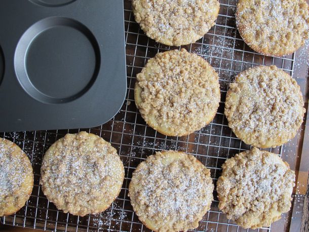 Crumb cake muffin tops on a cooling rack next to a muffin top pan.