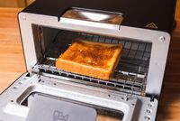 A toasted bread slice on a rack inside a toaster oven