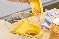 A person pours popcorn kernels into the Presto Poplite Hot Air Popper
