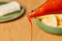 Person pouring Crystal Pure Hot Sauce