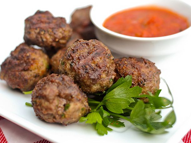 Platter of grilled meatballs with side of marinara sauce