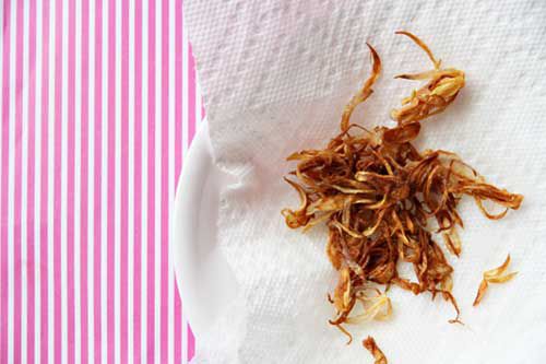 Golden brown fried shallots on a paper towel
