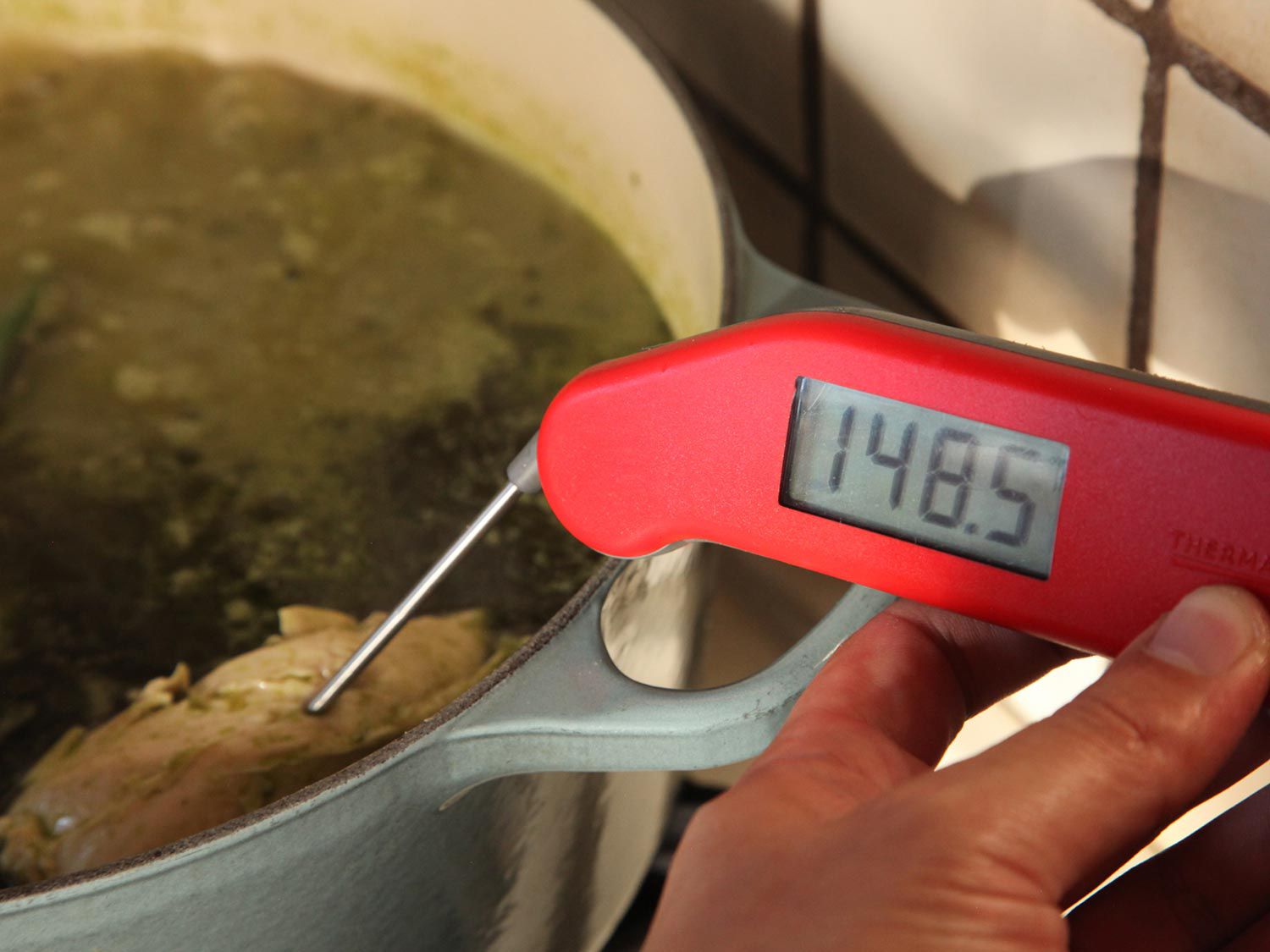 Instant read thermometer inserted in chicken, registering 148.5°F.