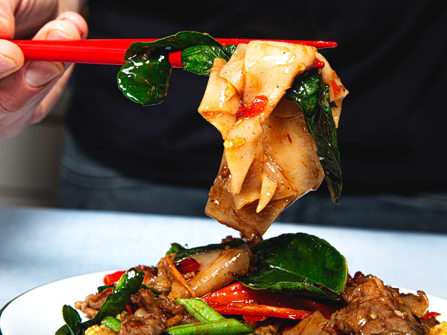 Lifting a bite of Pad Kee Mao 