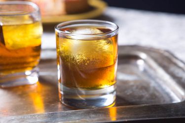 Old-fashioned cocktails served over ice in a rocks glasses on a silver tray
