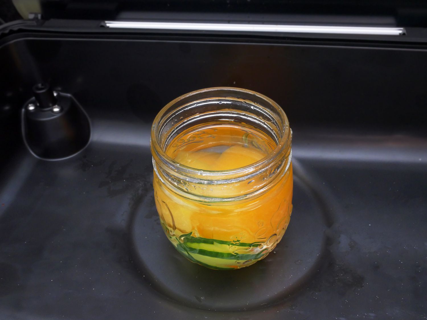 gin in a small mason jar with cucumbers and cantaloupe 