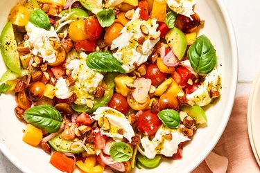 Tomato salad with sliced vegetables and fresh herbs in a bowl