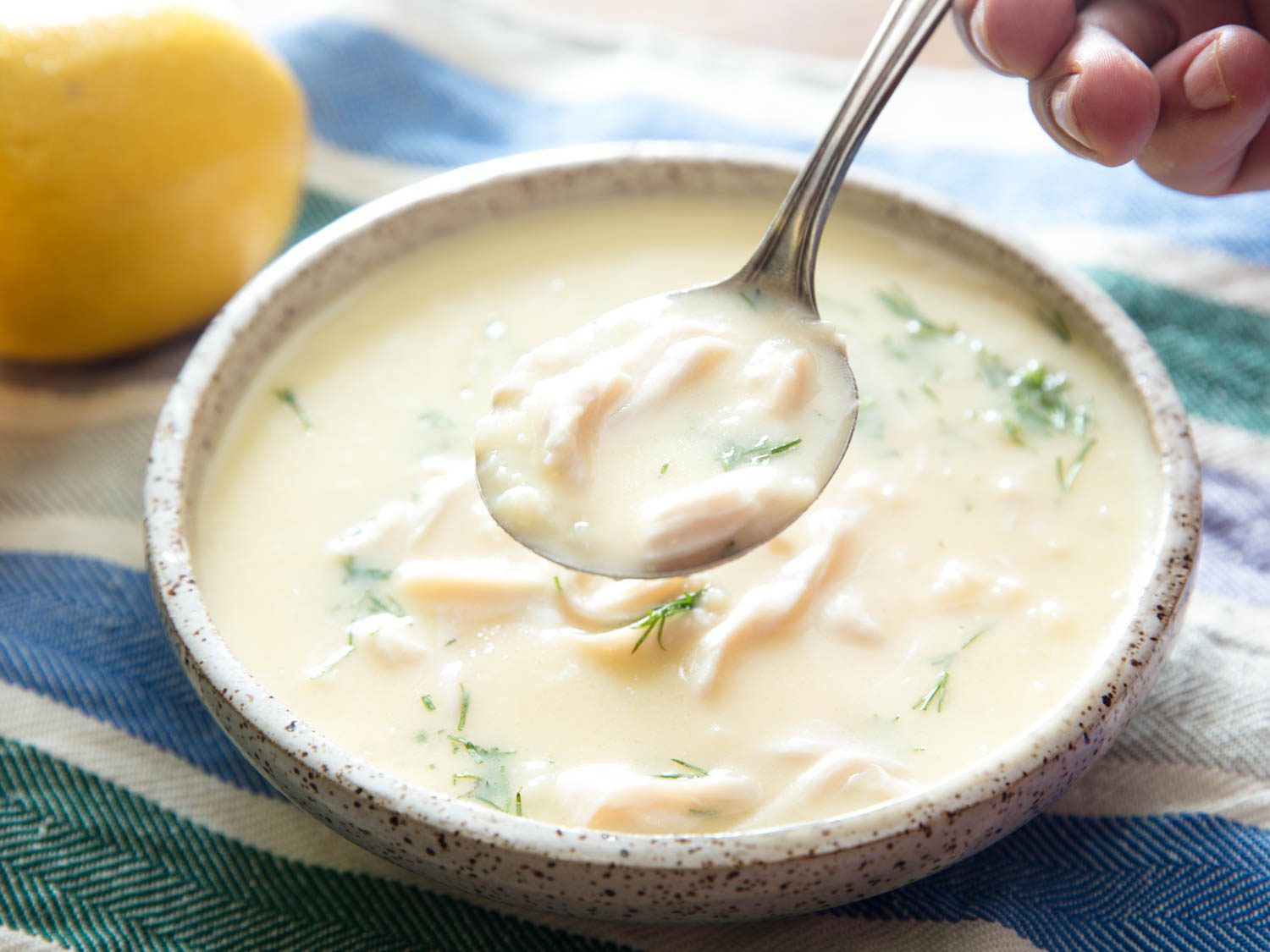 Spooning up some thick and creamy avgolemeno soup.