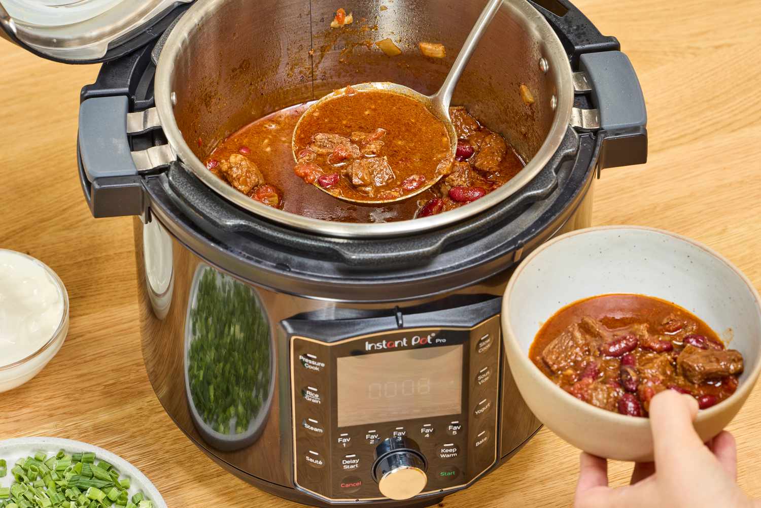 A person serves cooked soup in Instant Pot Pro 10-in-1 6-Quart Pressure Cooker