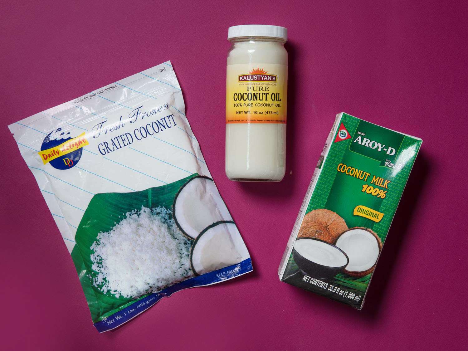 Overhead view of three packages of coconut products: grated coconut, coconut milk, and coconut oil.