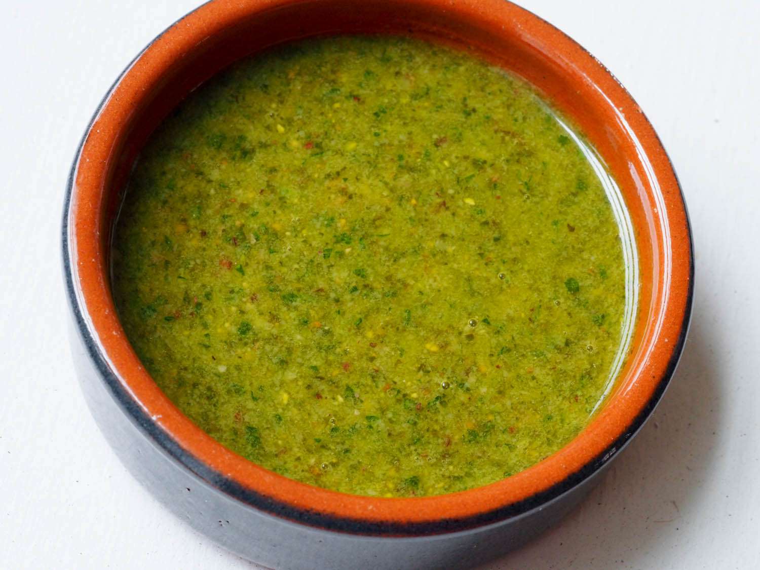 overhead shot of a shallow cazuela fllled with green, creamy feta pesto
