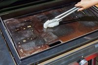 A person cleans the top of the Traeger Flatrock Flat Top Grill