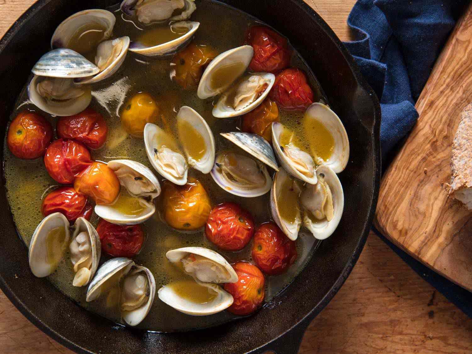 Final broiled clams and cherry tomatoes in a cast iron skillet
