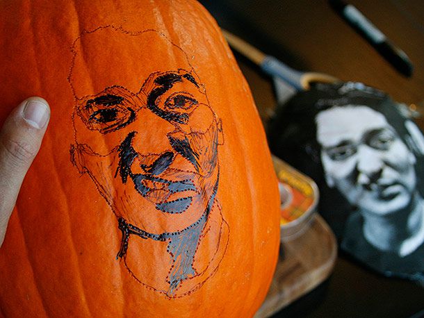 A face sketched on the surface of a pumpkin, with black and grayscale areas shaded in with marker