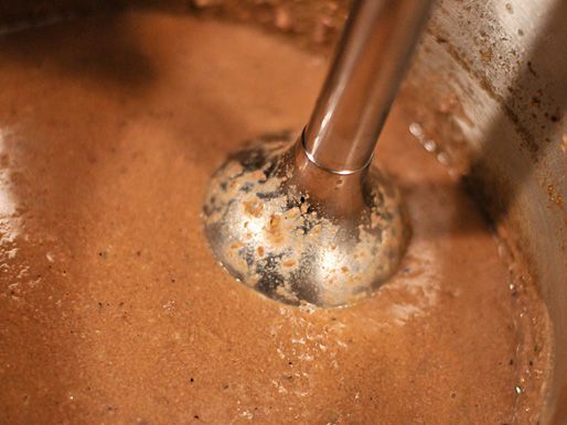 Blending pork liver sauce in the pot with an immersion blender. 