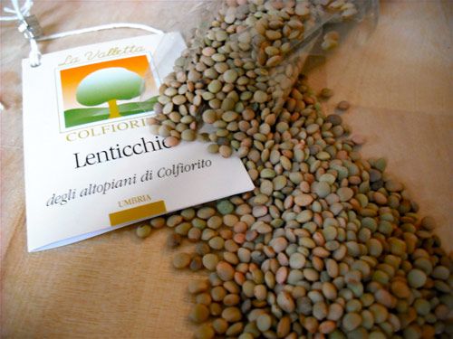 Green and pale pink Umbria lentils spilling out of their package
