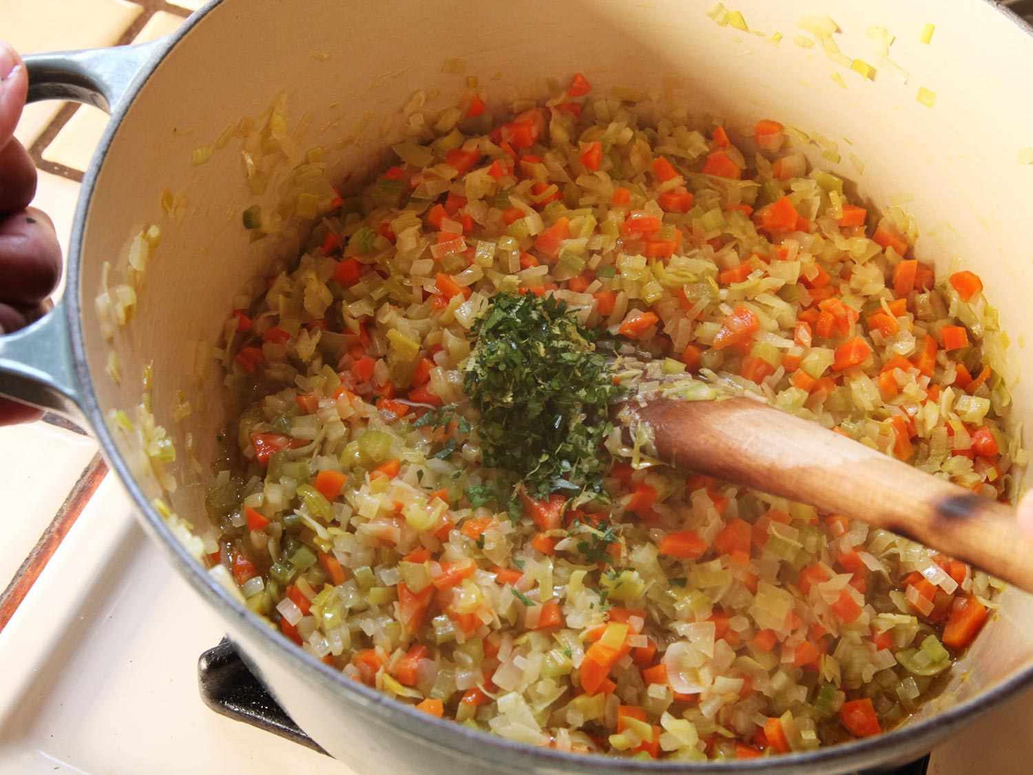 Stirring gremolata into lentil soup aromatics.