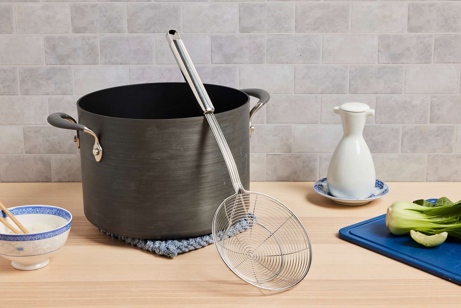 a spider skimmer resting on a stock pot