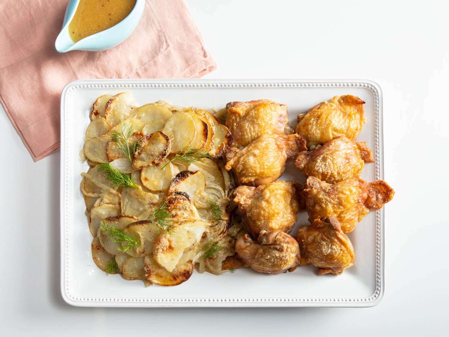 Roast chicken thighs with potato and fennel gratin on the table, ready to eat