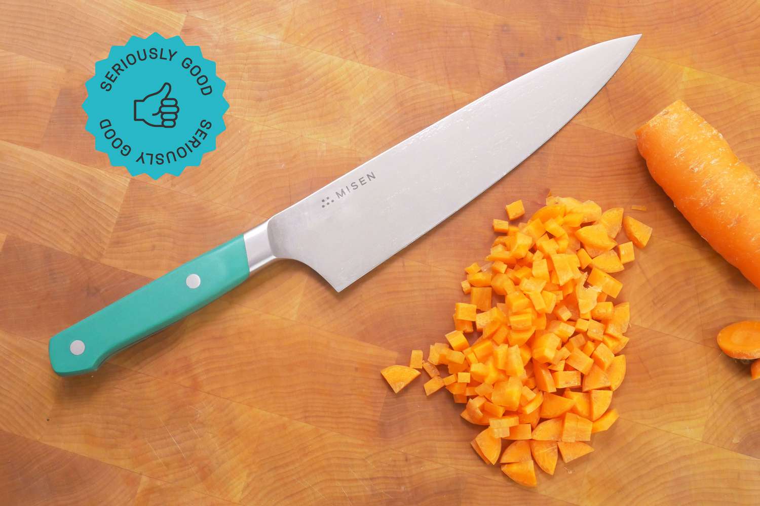 the misen chef knife on a wooden cutting board with a diced carrot