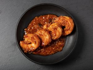 Ebichiri shrimp served on a black round plate.
