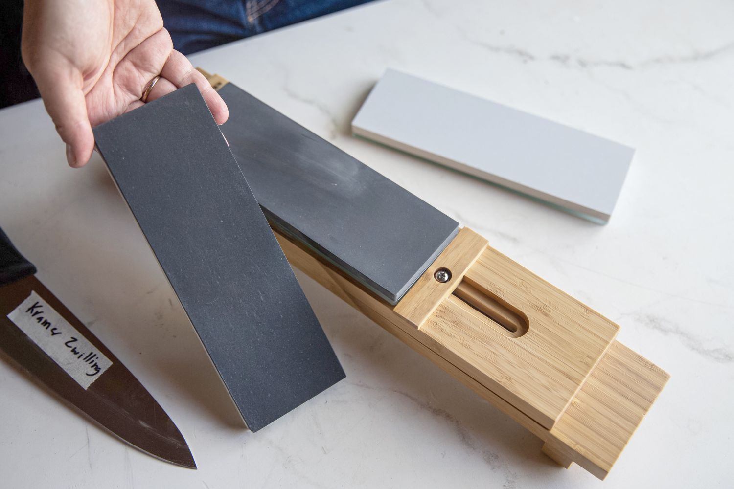 A person showing the different whetstones for a sharpener stone