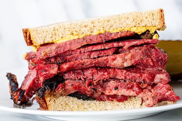 Close up of a pastrami on Jewish rye sandwich with spicy brown mustard