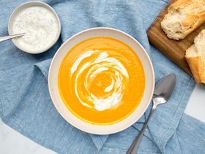 Carrot soup spooned into a white bowl.