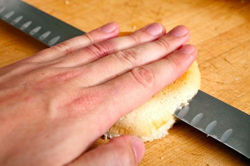 Author carefully slices the bottom off of a bottom bun.